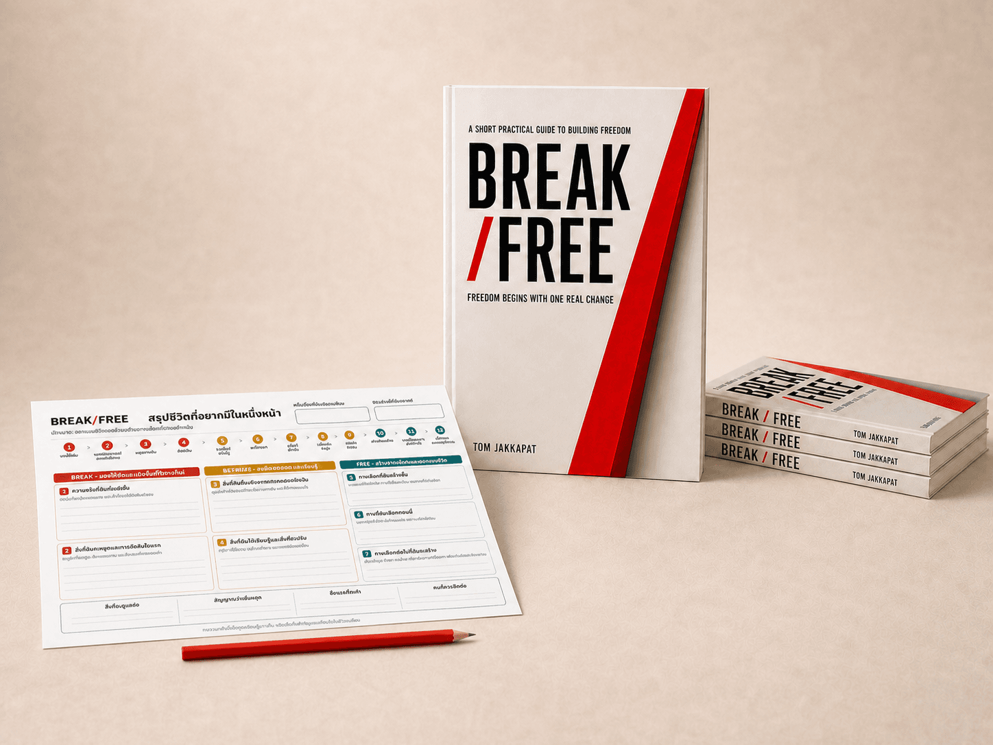 หนังสือ BREAK/FREE วางคู่กับแบบฝึกสรุปชีวิตที่อยากมีในหนึ่งหน้าฉบับภาษาไทยและดินสอสีแดง