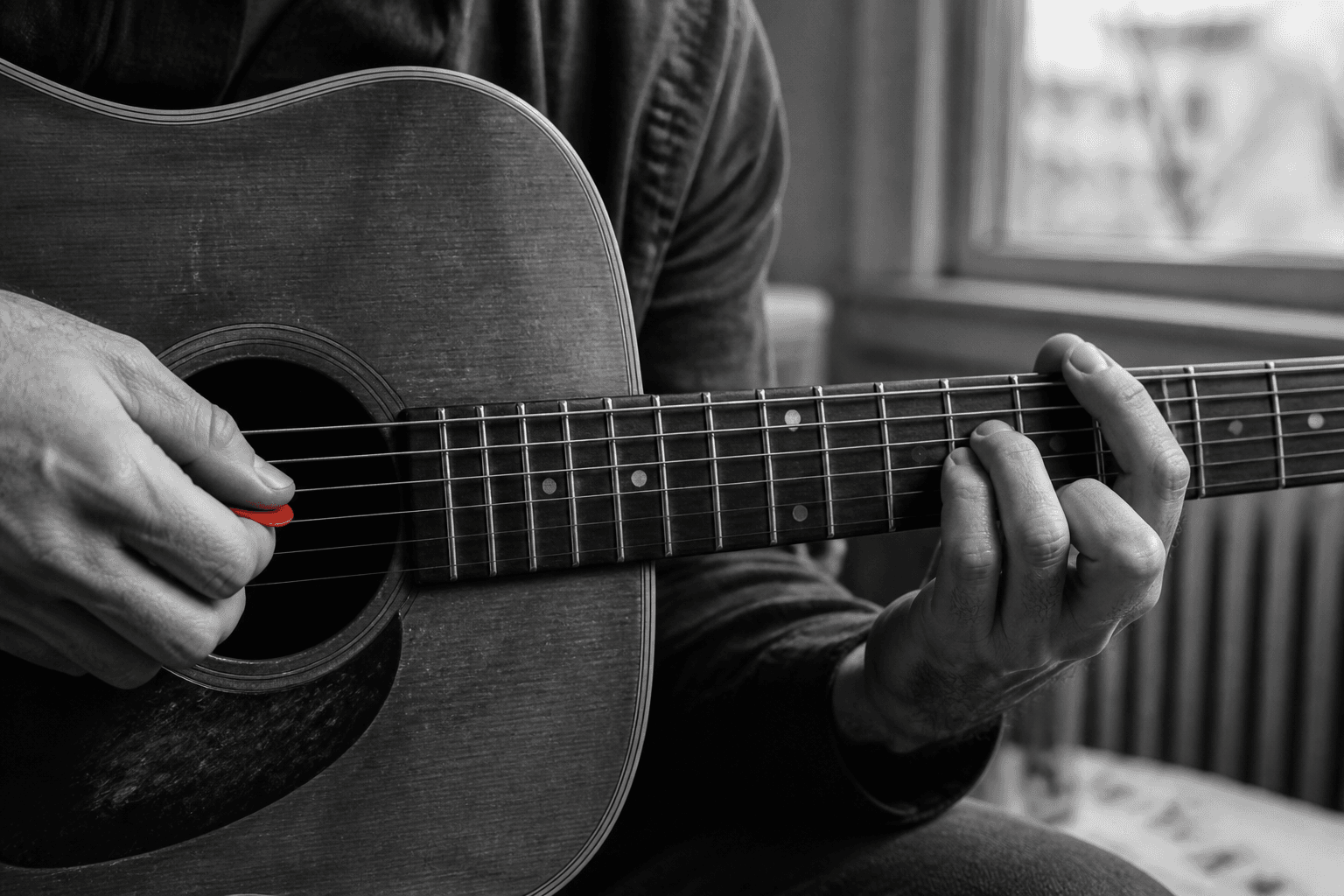 Hands practise a guitar chord in black and white, with a bright-red guitar pick as the only point of colour.